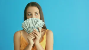 A girl in orange top having money in her hand